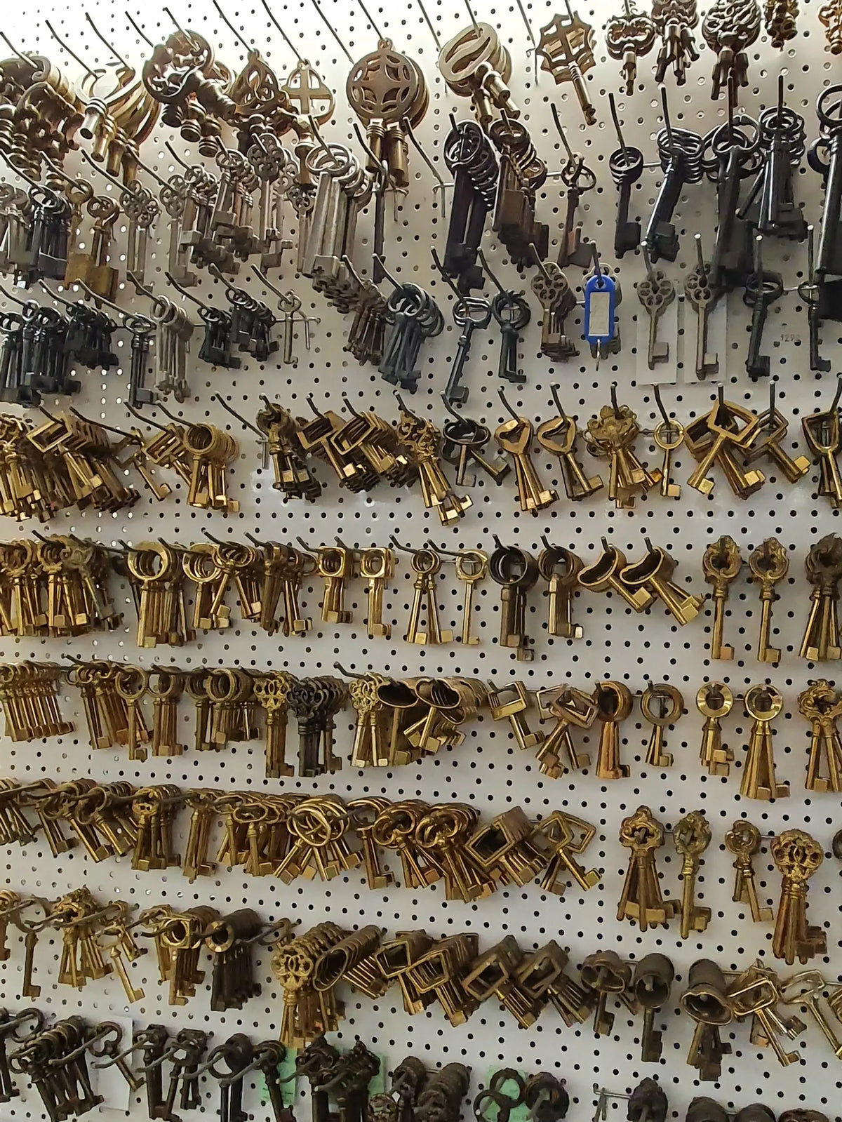 Messing-Möbelschlüssel und Bartschlüssel an der Schlüsselwand