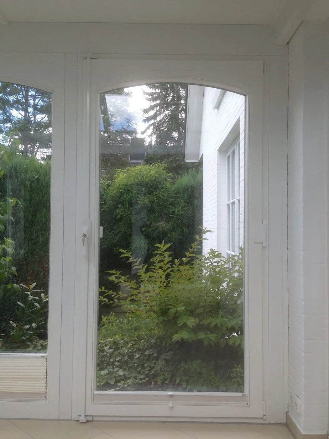 Zweiflügelige Terrassentür mit Rundbogen und Fenstersicherung